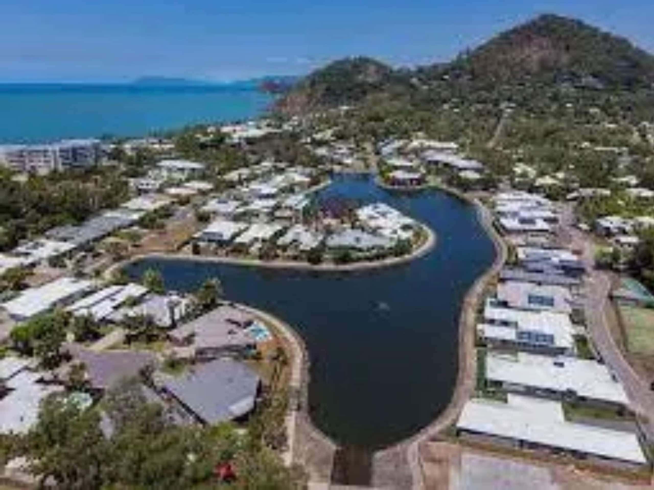 Aerial view of the Trinity Beach lagoon estate with the Coral Sea and headland beyond