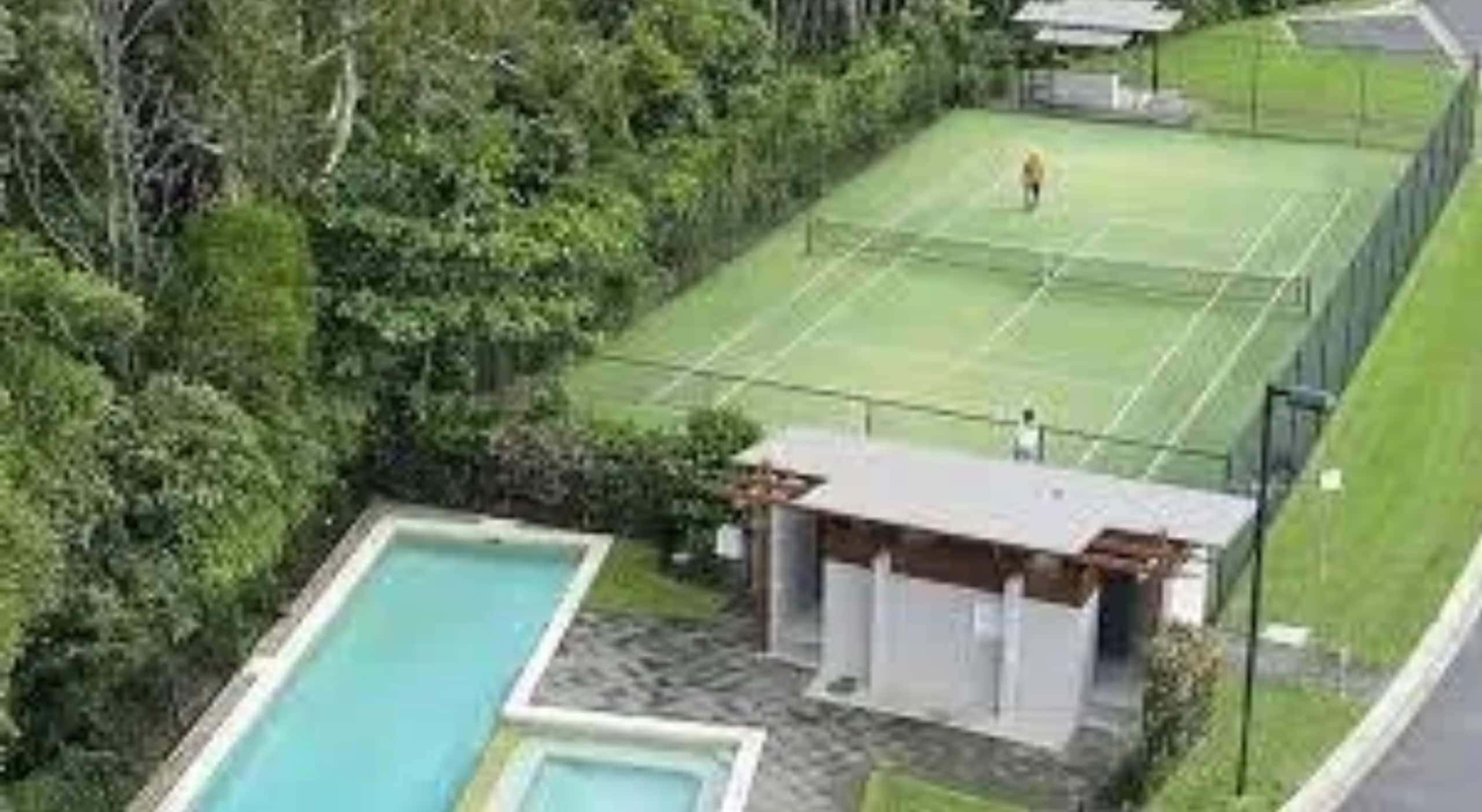 The estate tennis court and plunge pool tucked into tropical greenery